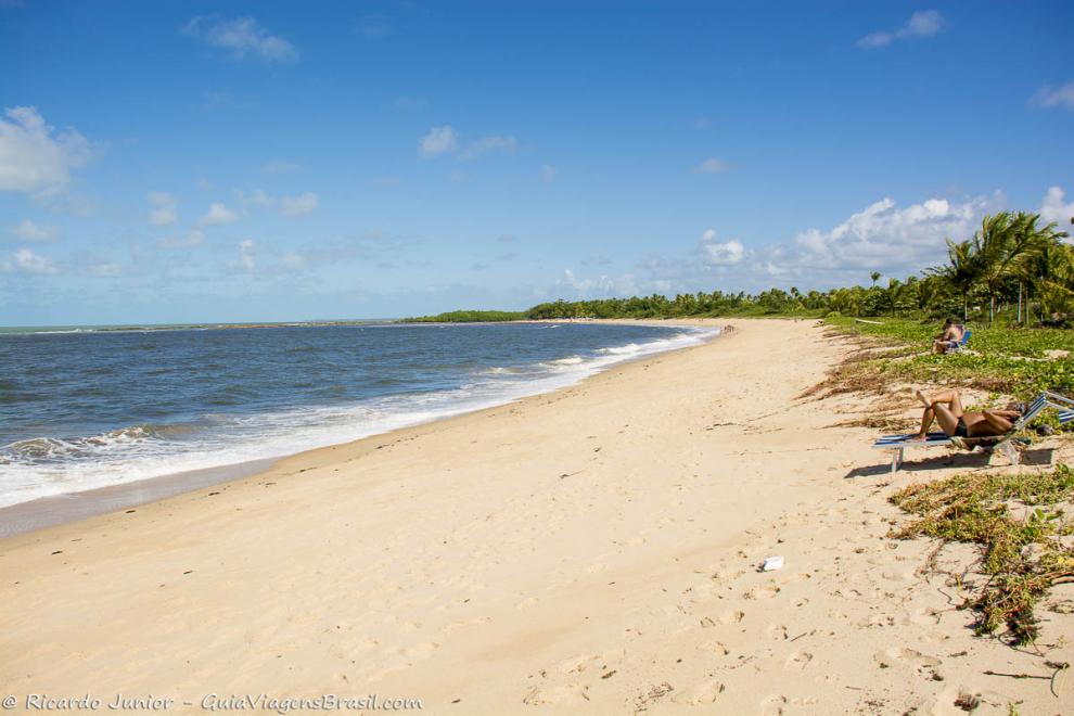 Imagem de turistas deitados na cadeira admirando a beleza da Praia de Santo André.